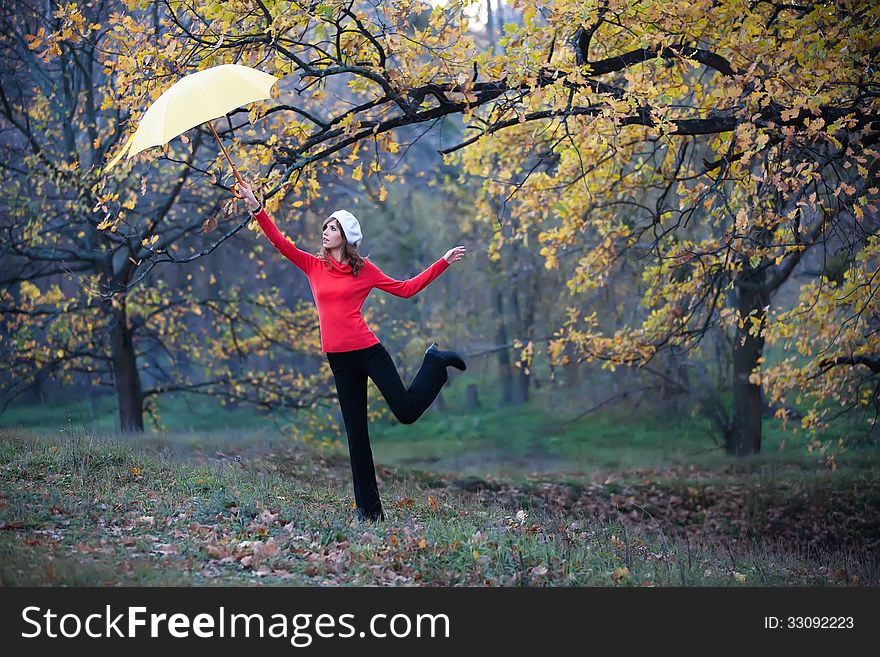 A girl with an umbrella in the autumn garden. A girl with an umbrella in the autumn garden
