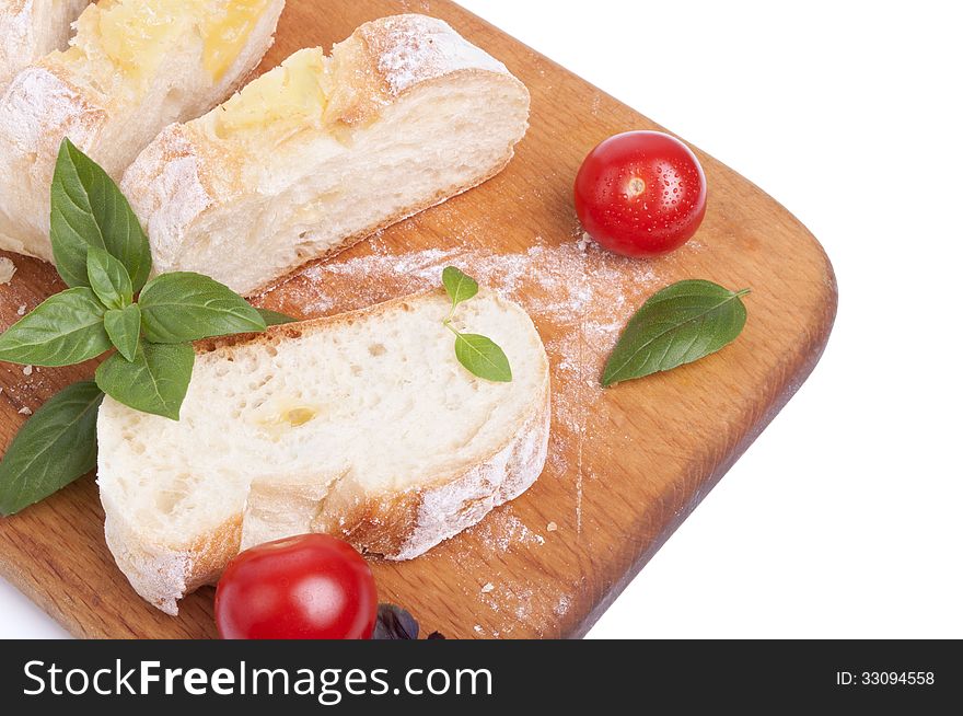 Cutted white bread with cheese on the wooden board with tomatos and basil. Cutted white bread with cheese on the wooden board with tomatos and basil