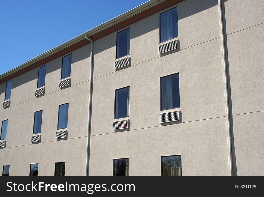 An exterior view of a hotel with windows. An exterior view of a hotel with windows