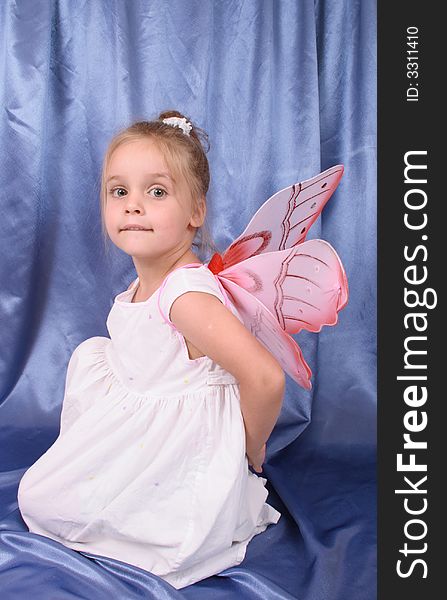 Young girl as butterfly on the blue background