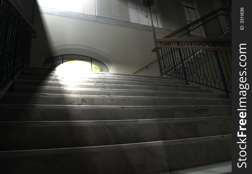 A solid white marble stair case accented by the morning sun light shining through upper windows. A solid white marble stair case accented by the morning sun light shining through upper windows