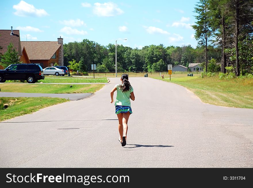 Young athletic girl running along a road. Young athletic girl running along a road