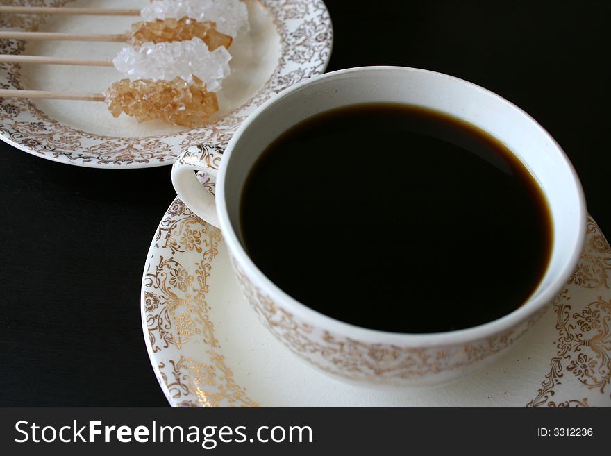 Coffee cup with plate in the background with sugar crystals. Coffee cup with plate in the background with sugar crystals