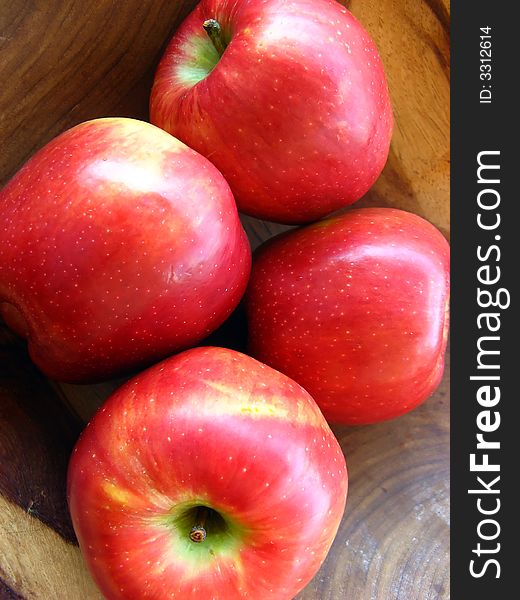 Red apples inside a wooden bowl macro