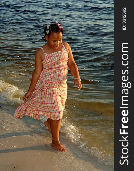 An african american girl walking along shoreline