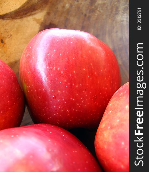 Red apples inside a wooden bowl macro