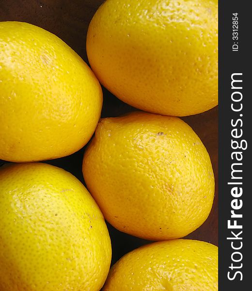 Some lemons inside a wooden bowl. Fruits