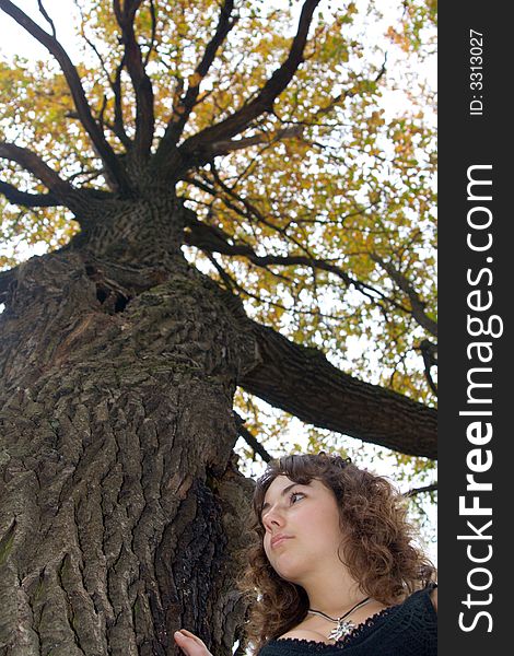 Face of girl standing near a tree at autumn park. Face of girl standing near a tree at autumn park.