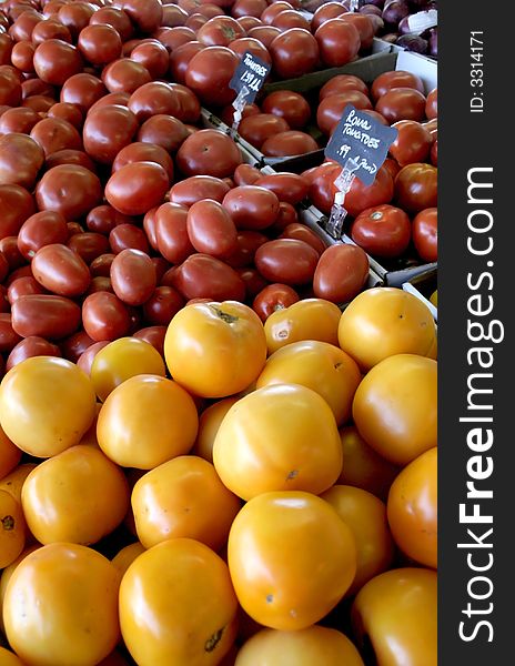 Yellow and red tomatoes in a pile waiting to be sold