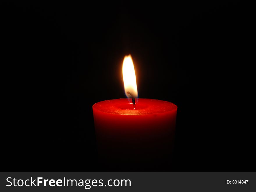Red condle, flame, black background. Red condle, flame, black background