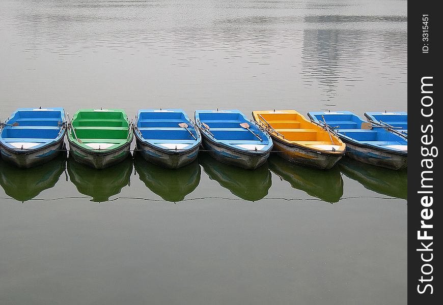 A row of colorful boats on the lake waiting for tourists. A row of colorful boats on the lake waiting for tourists