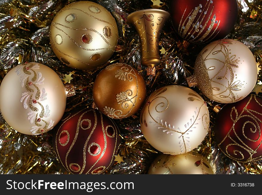 A few pieces of Christmas decoration - balls and a bell in white, red, gold and silver, with glittering background. A few pieces of Christmas decoration - balls and a bell in white, red, gold and silver, with glittering background.