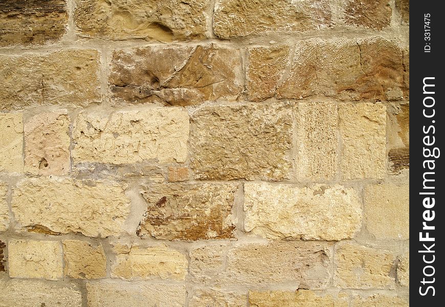Horizontal view of a layered, sandstone exterior wall building facade. A close up of a brick wall which can be used as background. Horizontal view of a layered, sandstone exterior wall building facade. A close up of a brick wall which can be used as background