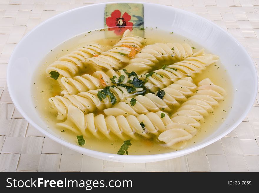 Delicious broth with pasta on a desk. Delicious broth with pasta on a desk