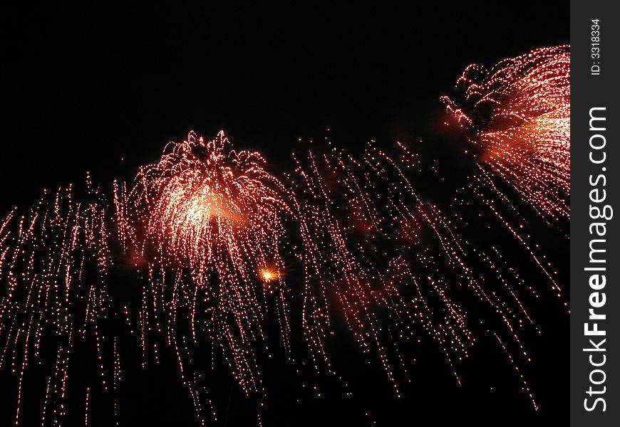 Red and orange fireworks over night sky