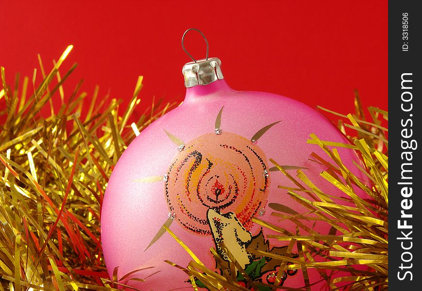 Pink christmas bauble with golden tinsel