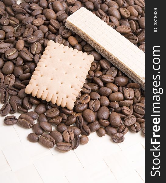 Coffee beans and biscuit on white background