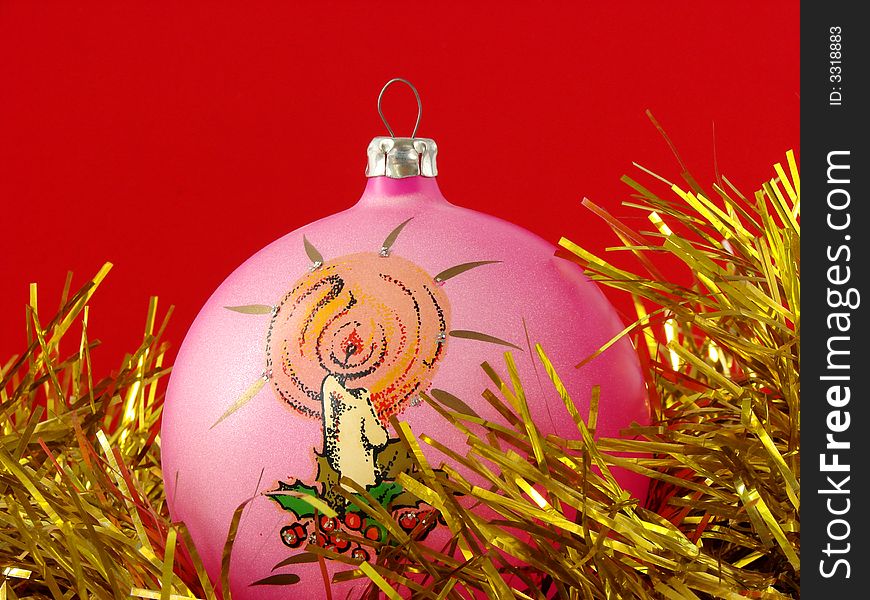 Pink christmas bauble with golden tinsel