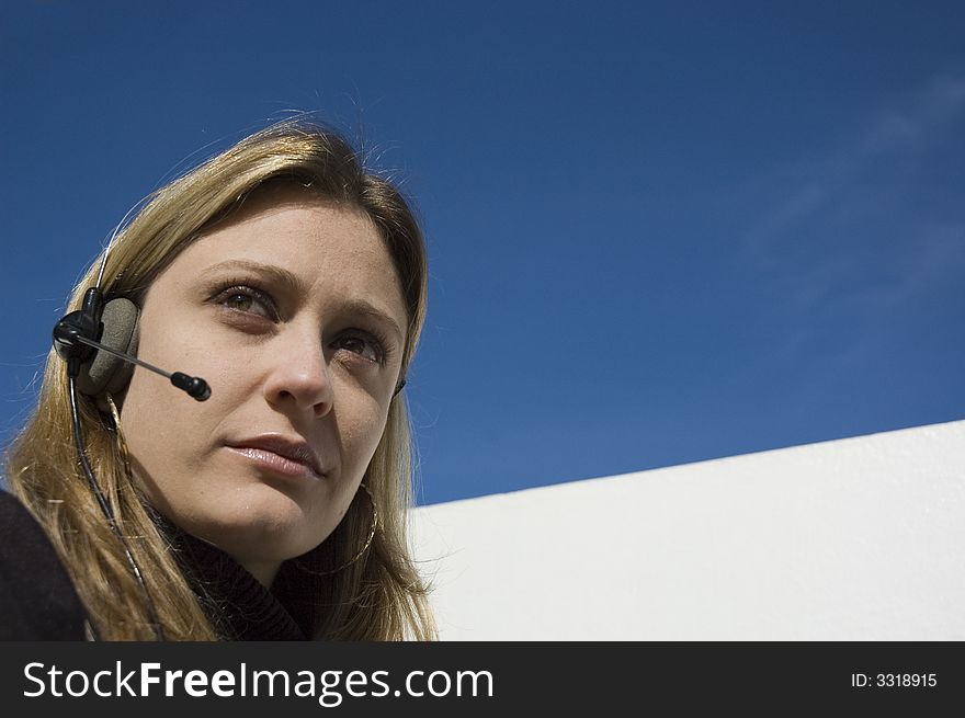 An isolated picture of a young female telemarketer / customer support officer, smiling as she works with a headset and microphone on her head. An isolated picture of a young female telemarketer / customer support officer, smiling as she works with a headset and microphone on her head.