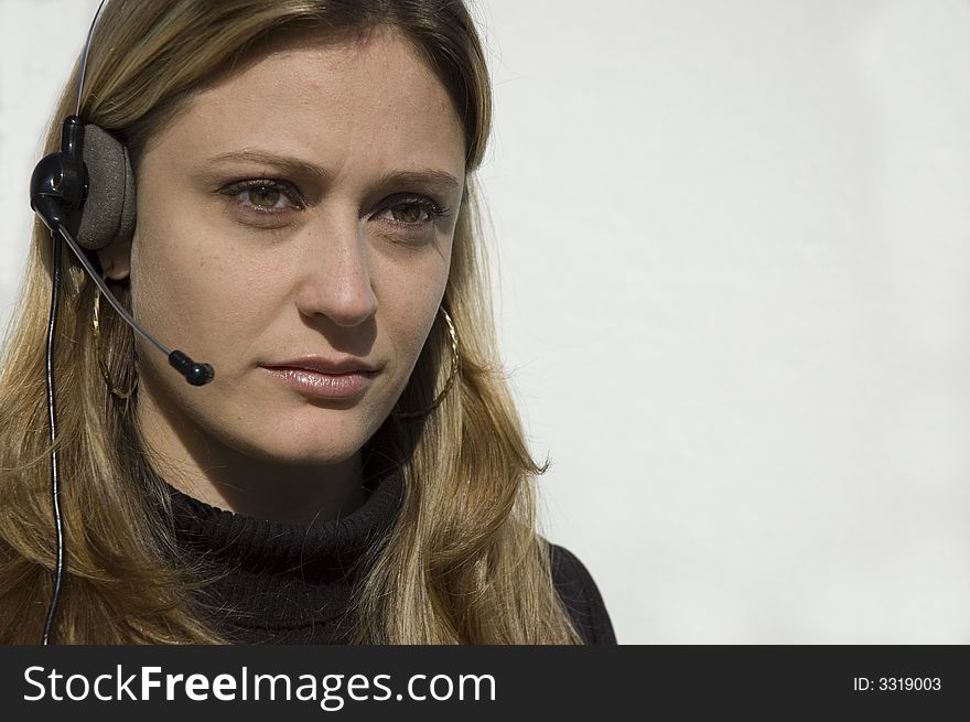 An isolated picture of a young female telemarketer / customer support officer, smiling as she works with a headset and microphone on her head. An isolated picture of a young female telemarketer / customer support officer, smiling as she works with a headset and microphone on her head.