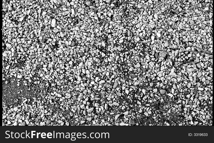 Black and white pebbles of different constiution on the road.  This is great for a background for anything colorful,
or a logo for it to show through. Black and white pebbles of different constiution on the road.  This is great for a background for anything colorful,
or a logo for it to show through.