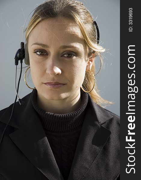 An isolated picture of a young female telemarketer / customer support officer, smiling as she works with a headset and microphone on her head. An isolated picture of a young female telemarketer / customer support officer, smiling as she works with a headset and microphone on her head.