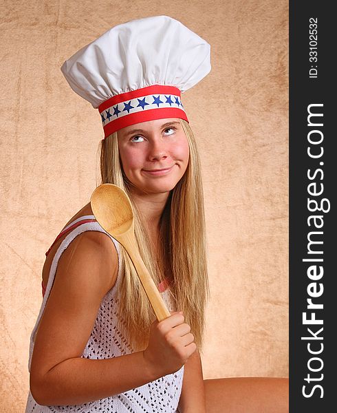 Teenage Female With Bakers Hat And Cooking Utensil. Teenage Female With Bakers Hat And Cooking Utensil