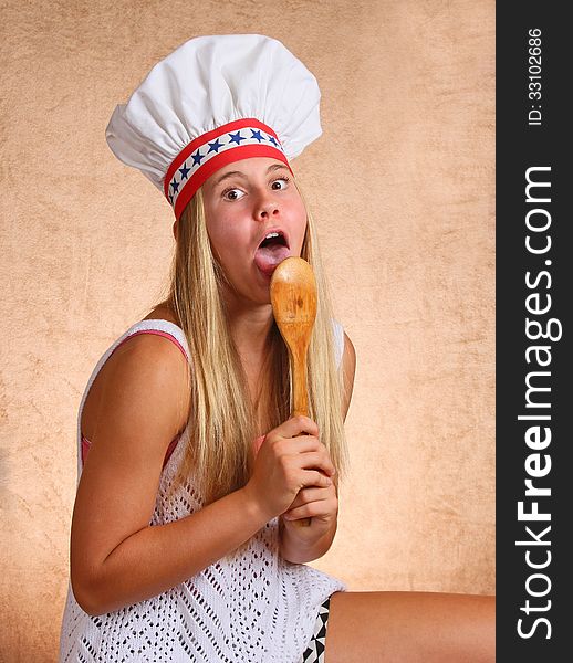 Teenage Female With Bakers Hat Licking Cooking Utensil Spoon. Teenage Female With Bakers Hat Licking Cooking Utensil Spoon