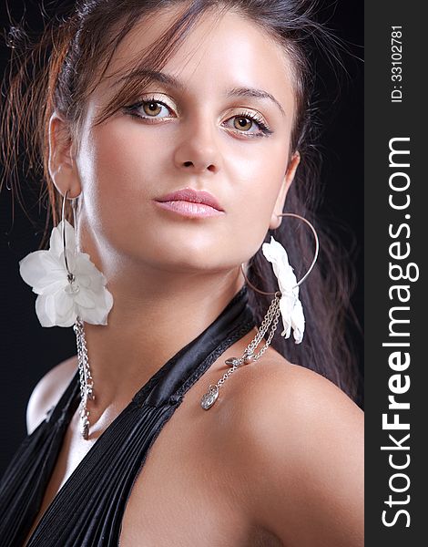 Portrait of a beautiful young brunette with earrings (close-up). Portrait of a beautiful young brunette with earrings (close-up)
