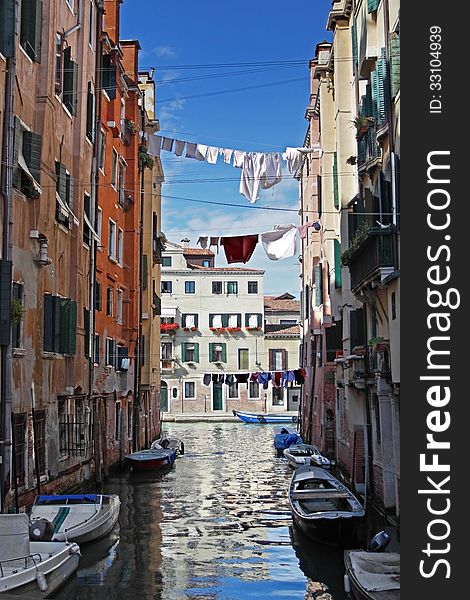 Venetian view with boats and drying clothes across the canal. Venetian view with boats and drying clothes across the canal