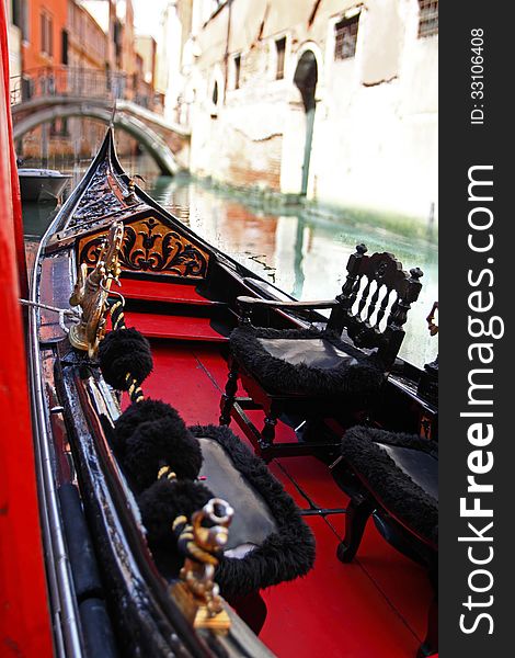 Venetian gondola closeup view with blurred bridge across canal on background