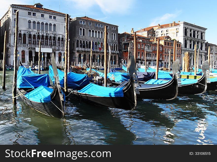 Venetian gondolas on canal with medieval buildings in background