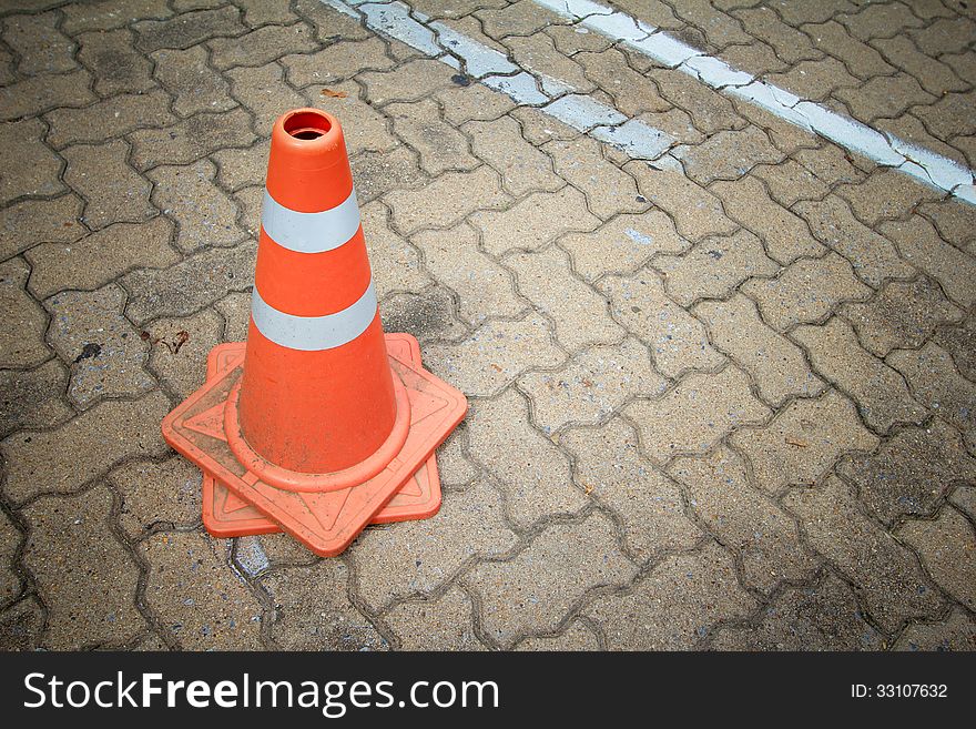 Red and white striped warning traffic cones stand on car park. Red and white striped warning traffic cones stand on car park