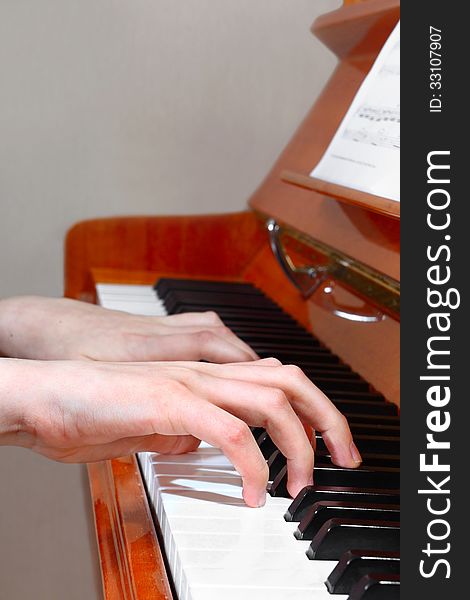 Closeup of hands playing the piano. Profile view. Closeup of hands playing the piano. Profile view