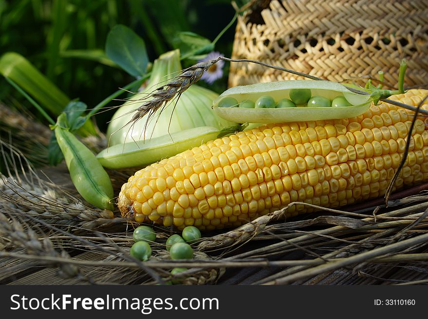 Ear of corn, peas, onion and straw hat.