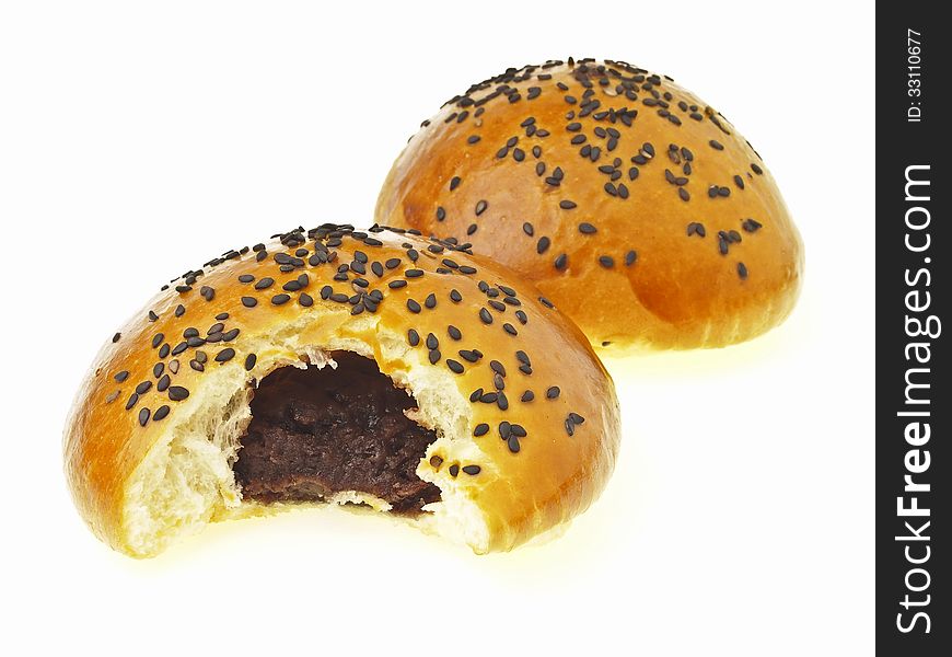 Bite of delicious red bean black sesame filled bun on white background