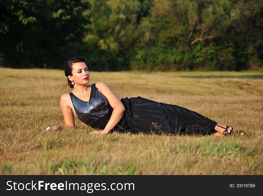 Woman lying in grass smiling happy.Beautiful girl in summer relaxing.