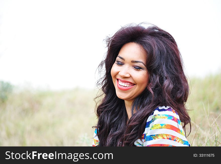 Happy laughing face of an attractive young woman with long blac hair. Happy laughing face of an attractive young woman with long blac hair.