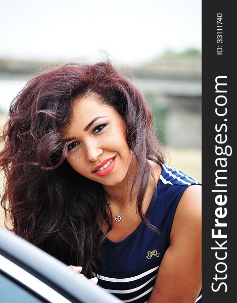 Outdoor portrait of an attractive young woman with long blac hair.