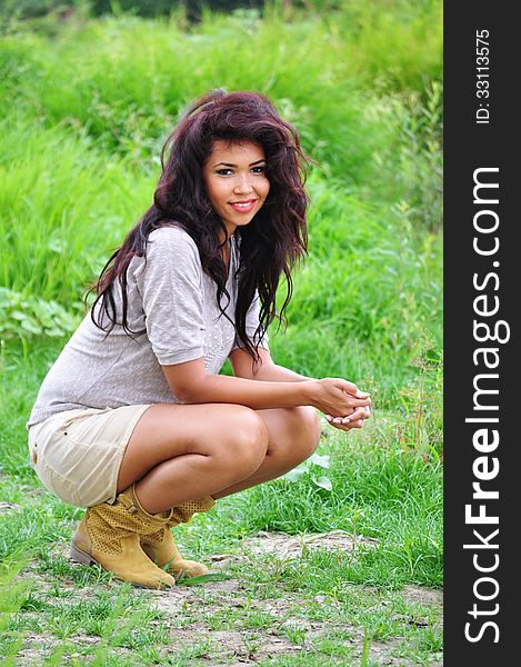 Outdoor portrait of an attractive young woman with long blac hair.