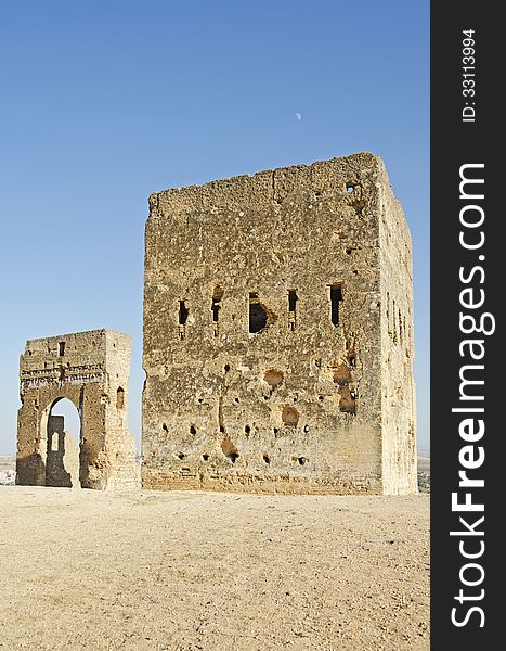 The Tombeaux Des Merindes ruins that sit above the Moroccan city of Fes with the Moon sitting above the main part of the fort. The Tombeaux Des Merindes ruins that sit above the Moroccan city of Fes with the Moon sitting above the main part of the fort.