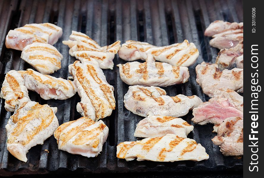 Fillet of chicken is fried on a grill. Fillet of chicken is fried on a grill