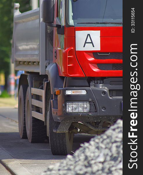 Red truck close up and a pile of gravel in foreground. Red truck close up and a pile of gravel in foreground