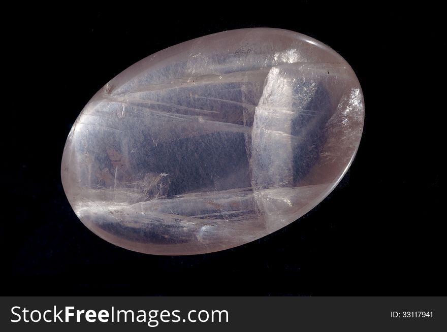 A large polished egg-shaped nugget of rose quartz, transilluminated