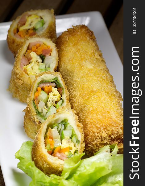 Deep Fried roll salad mix meal on white plate