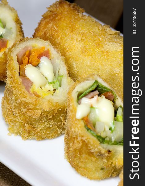 Deep Fried roll salad mix meal on white plate