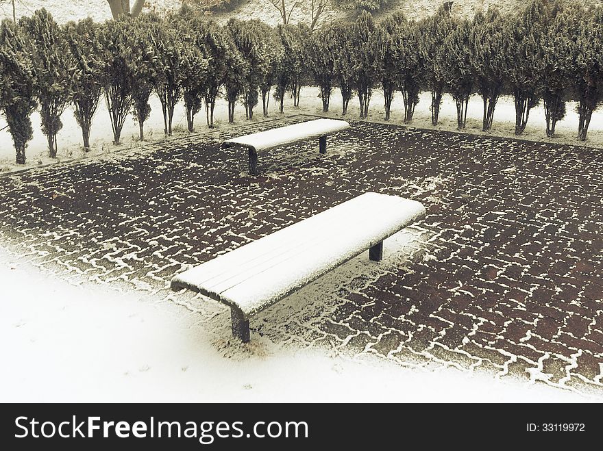 Two benches under fresh snow in city park. Two benches under fresh snow in city park