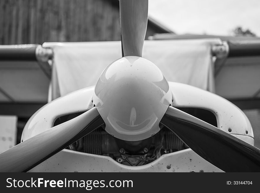 Front part of fuselage of a small light aircraft shot in black-and-white at a close distance. Front part of fuselage of a small light aircraft shot in black-and-white at a close distance