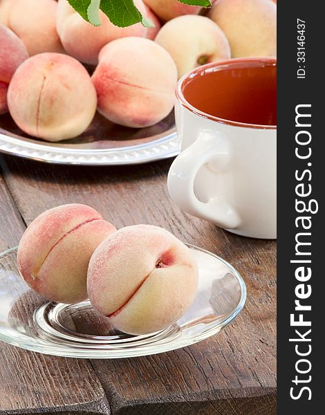 Goldish velvety ripe peaches on a glass saucer