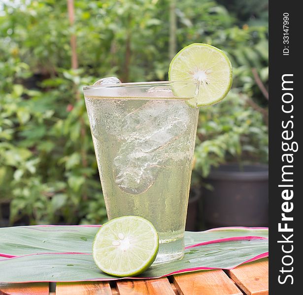 Cold lemonade in a glass with ice cubes